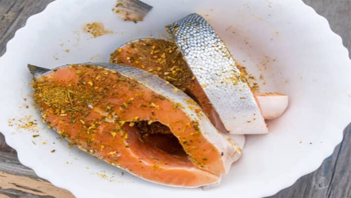 Hình ảnh tẩm ướp gia vị cá hồi và cắt ra từng miếng vừa ăn